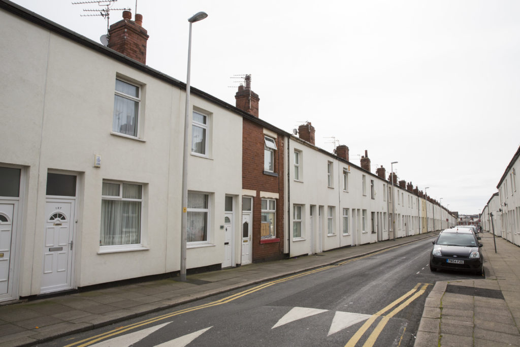 A street of terraced houses that have been retrofitted with external wall insulation. 