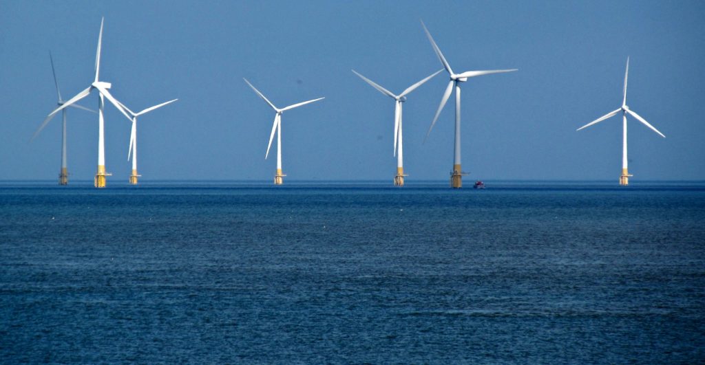 An offshore windfarm with seven wind turbines standing in the sea. 