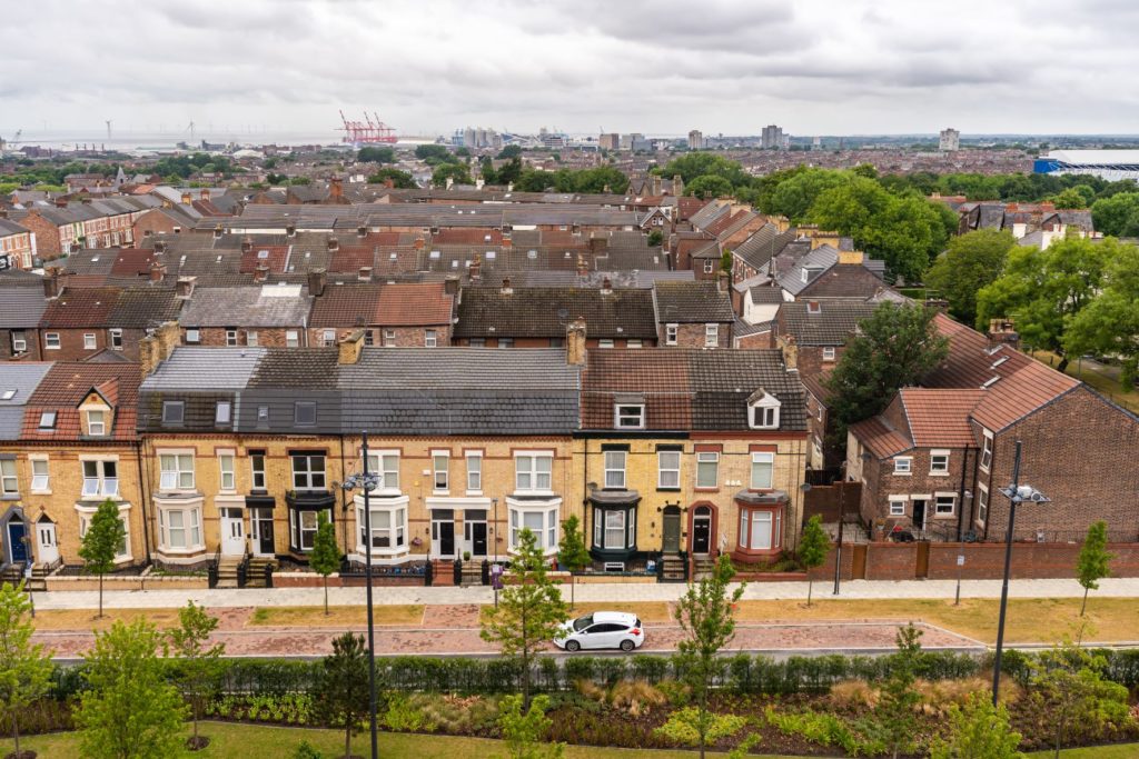 Aerial view of housing complex rooftops adjacent to a green park.