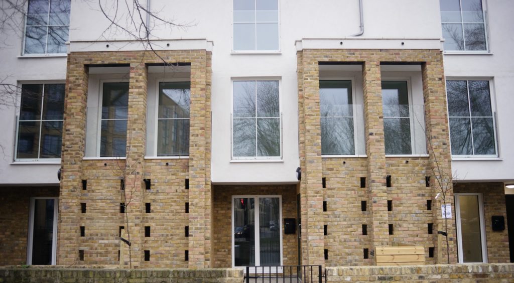 A Passivhaus home - a modern building with some exposed brick features and white walls, with large windows. 