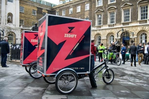 A Zedify e-cargo bike, featuring a large pink and black haulage container on the back of the bike. 